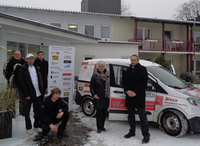 Team des Lambertistifts steht bei der Übergabe eines neuen Fahrzeugs vor dem Gebäude.