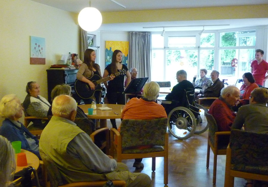 FSJlerinnen spielen Gitarre und singen für Bewohnerinnen und Bewohner im Lambertistift.
