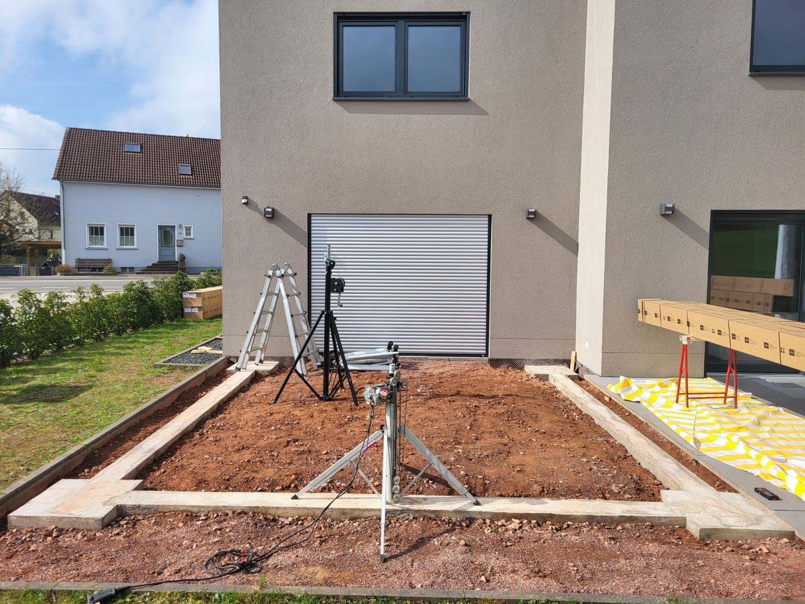 Lamellendach_vorher_Saarland_Rolladen_Kessler Streifenfundament auf einem Teil der Terrasse, auf der noch kein Bodenbelag liegt, durch ein Schiebelement kommt man raus auf die Terrasse
