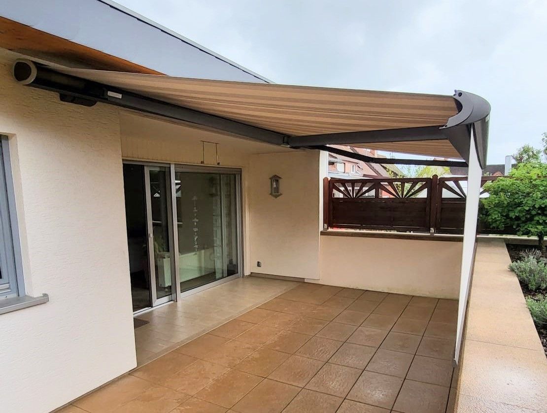 markise_Volant_plus_weinor_neu_Saarland_Rolladen_Kessler weinor Kassettenmarkise mit gestreiftem Markisentuch und Volant plus vorne gegen tiefstehende Sonne.