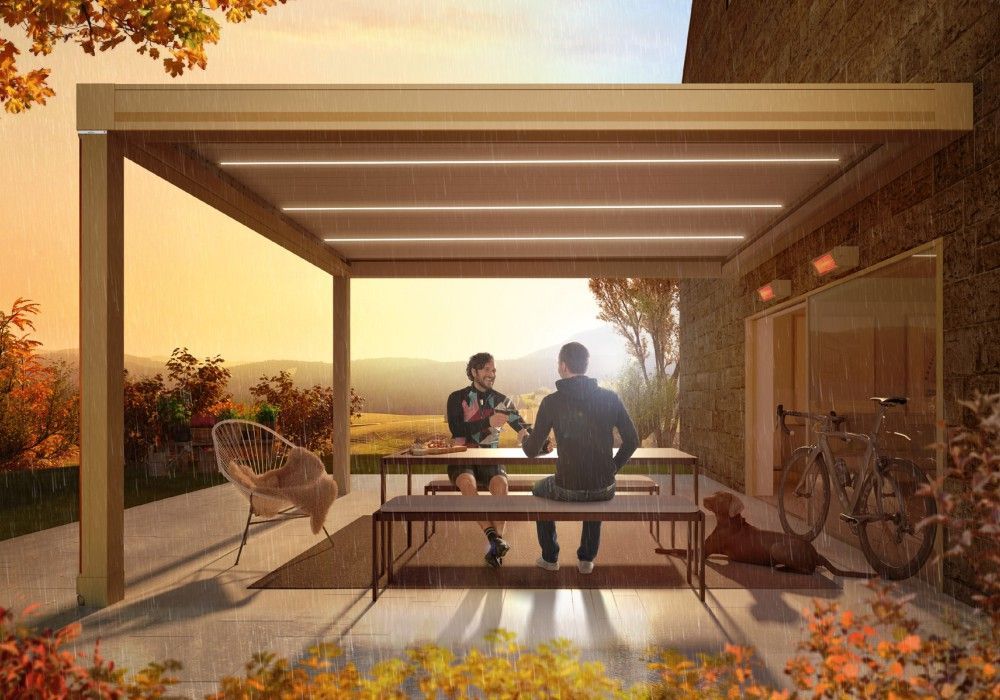 Kurz vor Sonnenuntergang auf einer Terrasse im Herbst. die Heizstrahler Tempura sind an und 2 Menschen sitzen unter einem weinor Lamellendach.