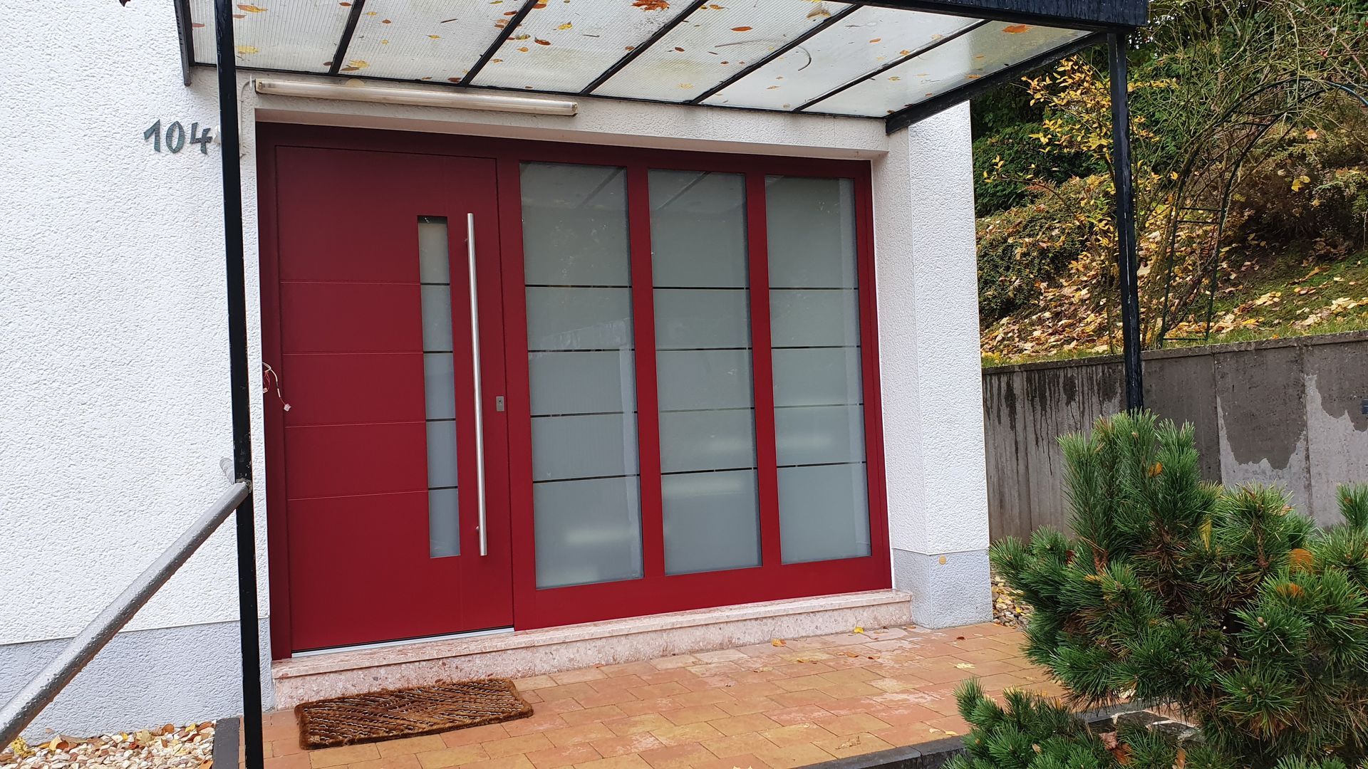 Aluminium-Haustür mit Seitenteil Aluminium-Haustür mit Seitenteil, die Klarglasstreifen in der Tür werden im Seitenteil weitergeführt.