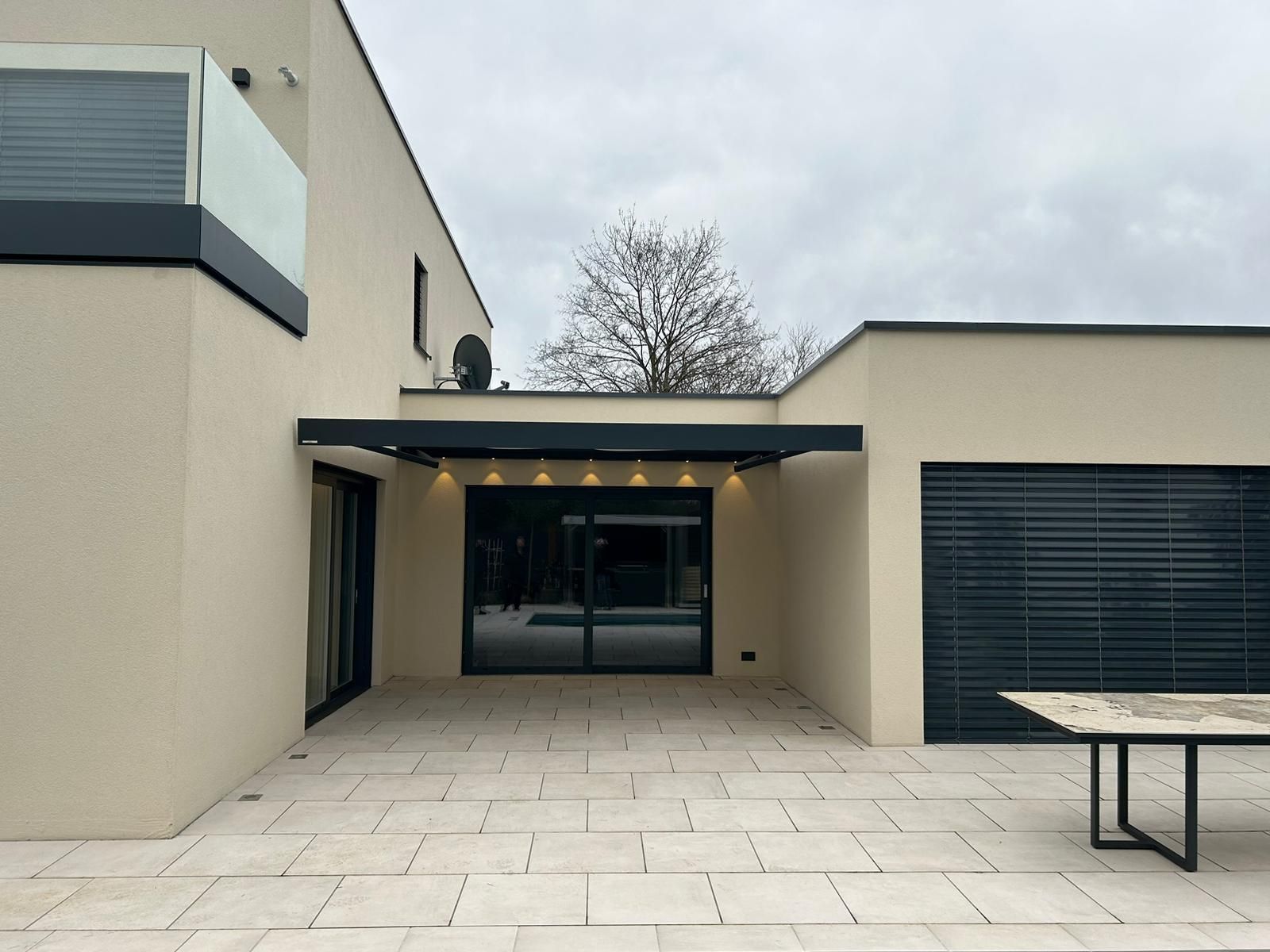 weinor_Markise_LED_neu_Saarland_Rolladen_Kessler Markise Kubata LED ist in der Wandnische montiert, die LED leuchten und die anthrazitfarbene Markise ist ausgefahren.