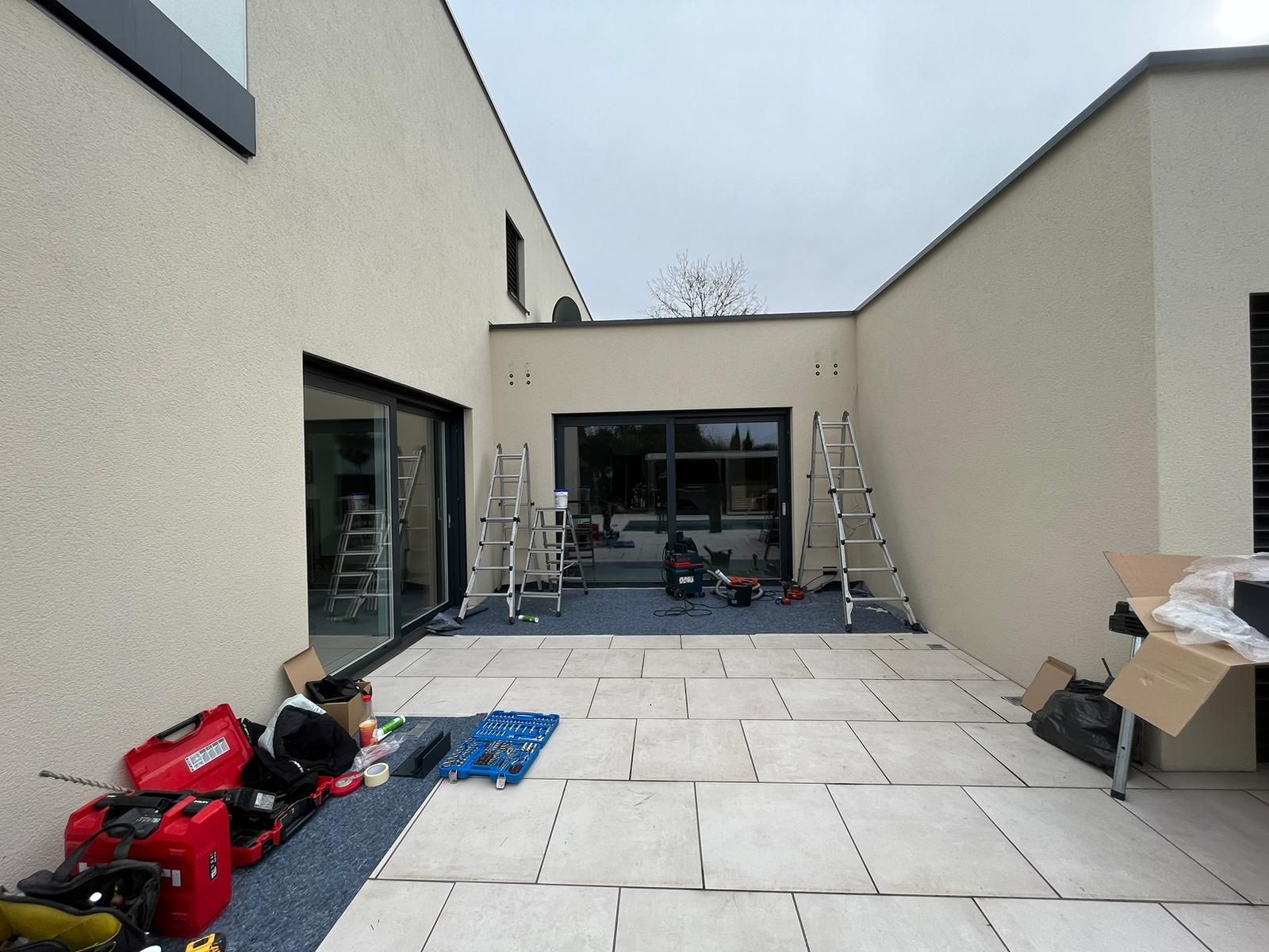 keine_Markise_vorher_Saarland_Rolladen_Kessler Wandnische mit großem Schiebeelement. Unsere Monteure haben den Boden bereits abgedeckt und die Leitern zur Markisenmontage aufgestellt.