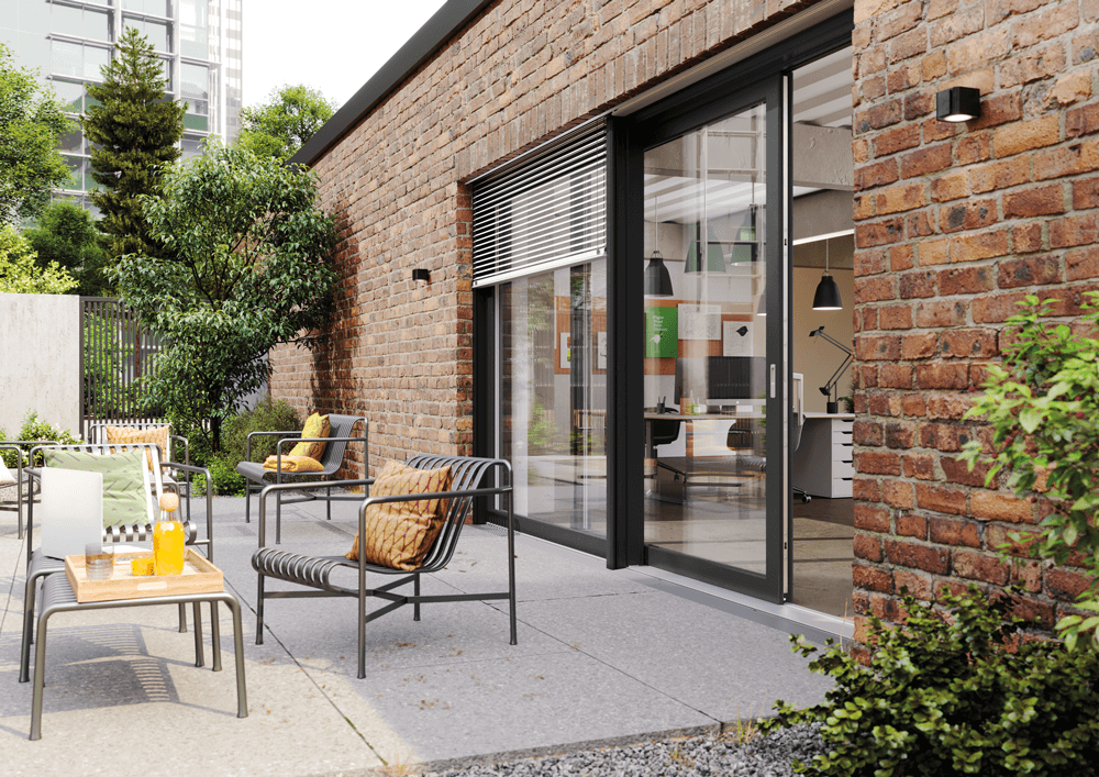 Eine Terrassensituation mit Möbeln. Dahinter ein ALEGRA Hebe-Schiebe-Element von Weru in dunkelgrau.