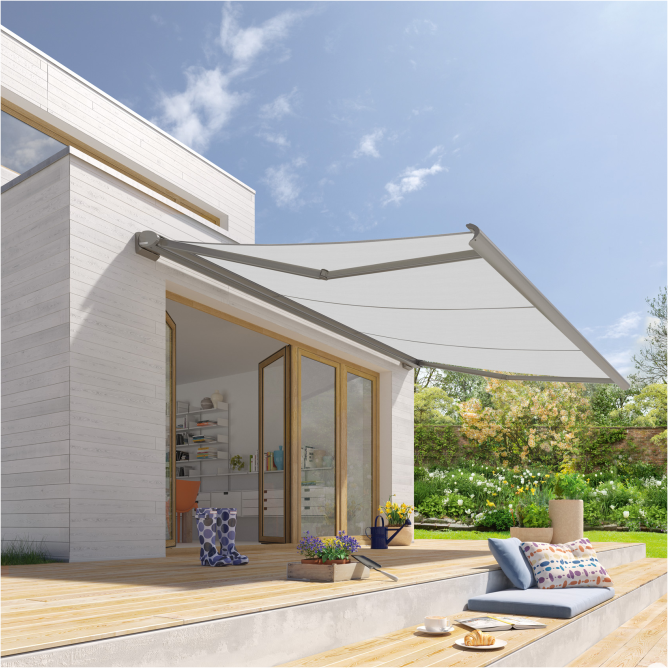 Ein modernes Haus in einer kubischen Form und betonfarbenen Außenwänden. Über einer breiten Balkontür in Holzoptik ist eine Kassettenmarkise des Typs Cassita von weinor in einem graubeigen Farbton montiert.