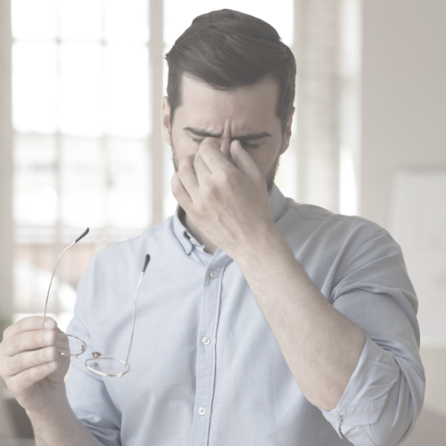Symptome von Trockenen Augen Männliche Person, die sich mit Zeigefinger und Daumen in die Augen greift, vermutlich weil Beschwerden auftraten