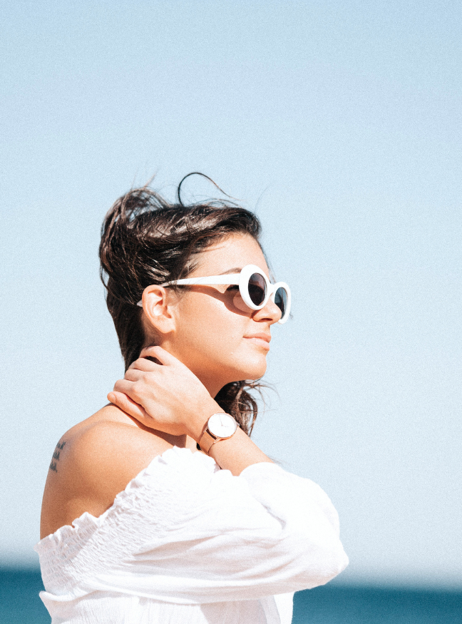 Person mit einer Sonnenbrille am Strand