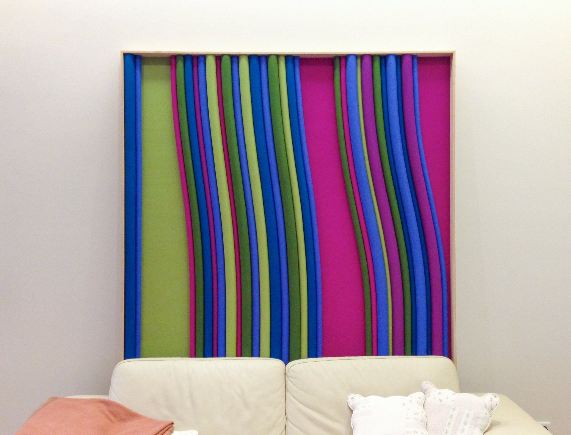 Bilding in den Farben Blau, Grün und Lila hinter einem Sofa Grübbel Architektur. Atelier. Bilding