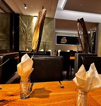 Stimmungsvolles Restaurantinterieur im Schlosscafé Heimbach mit elegant gedeckten Tischen und warmem Licht