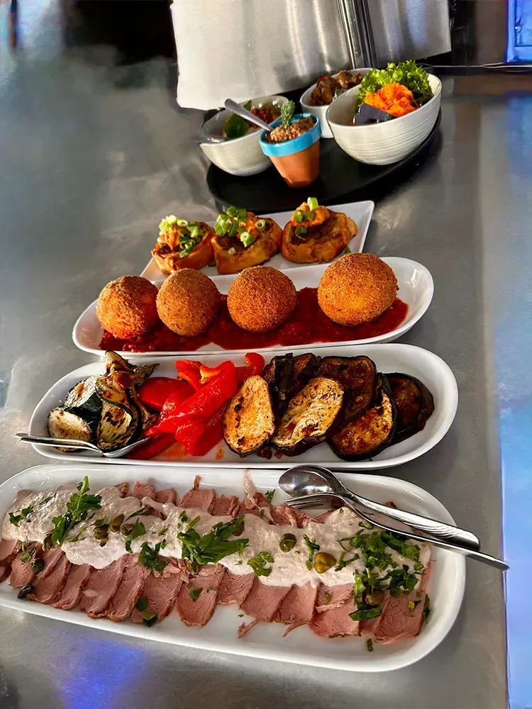Tisch mit verschiedenen Antipasti, gegrilltem Gemüse und mediterranen Vorspeisen