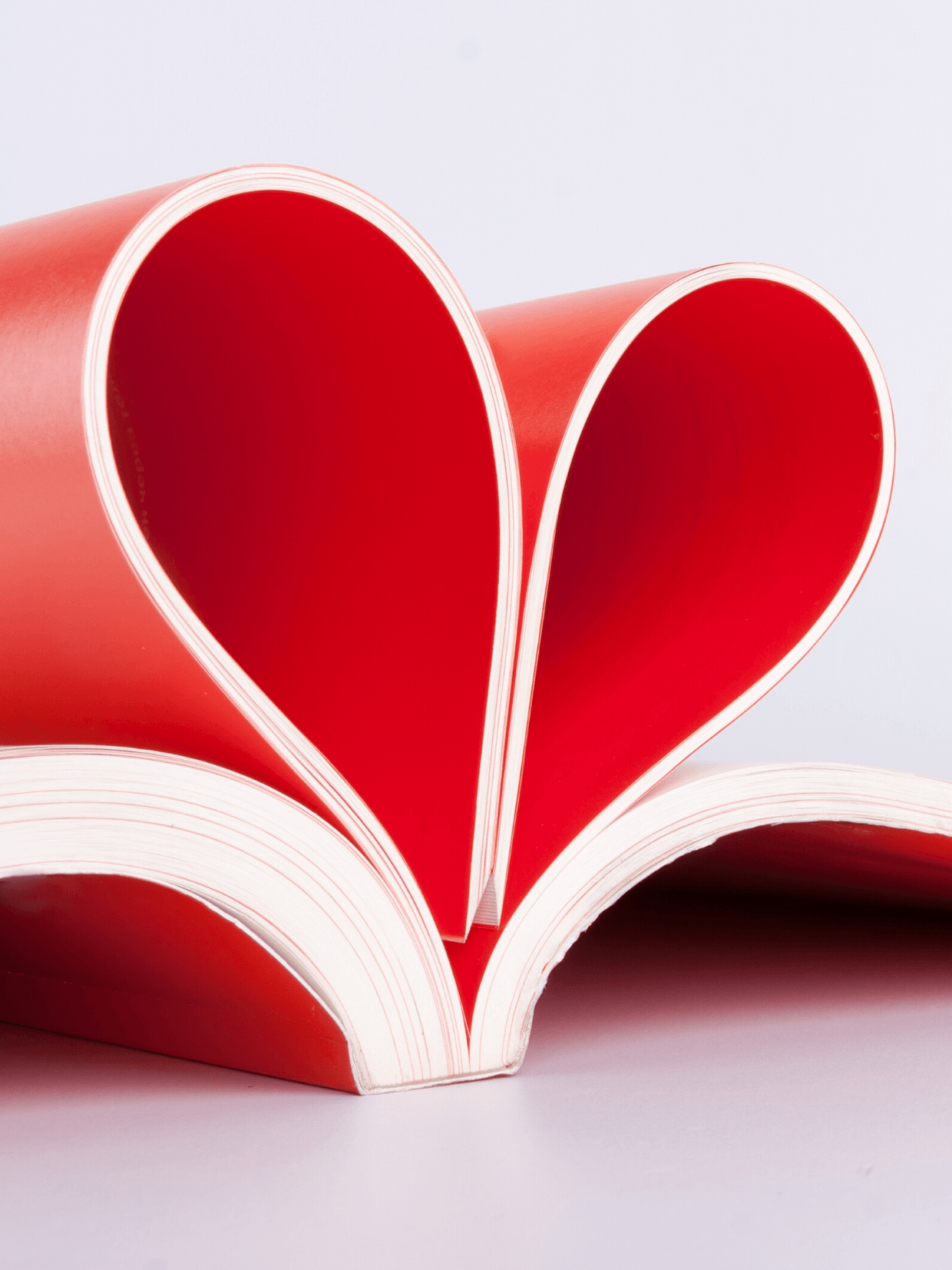 OPTIMUM Medien & Service GmbH. Medien für Unternehmenskommunikation. Magazin als Herz aufgefaltet. Symbol für Unternehmenskommunikation. Medien