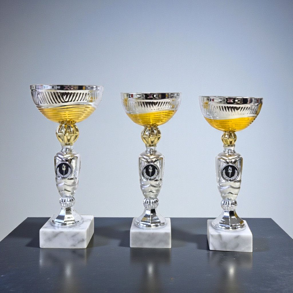 Silberfarbener Pokal, mit goldener siloutte auf weißen Marmorsockel