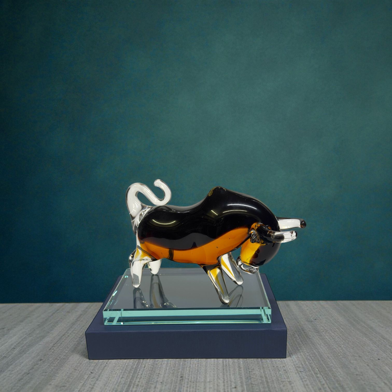 Der Black Amber Bull Award vereint exklusive Handwerkskunst aus Glas mit der energievollen Symbolik des Stiers. Die Kombination aus tiefem Schwarz und warmen Bernsteintönen macht diesen Award zum echten Blickfang auf jedem Schreibtisch oder in jeder Trophäenvitrine. Ideal als Business-Award für Banken, Investment-Unternehmen, Börsenerfolge oder als hochwertige Sport-Trophäe für Bewerbe mit Kraft- und Kampfgeist. Lieferung auf edlem Glassockel inklusive Lasergravur auf dem Unterbau.