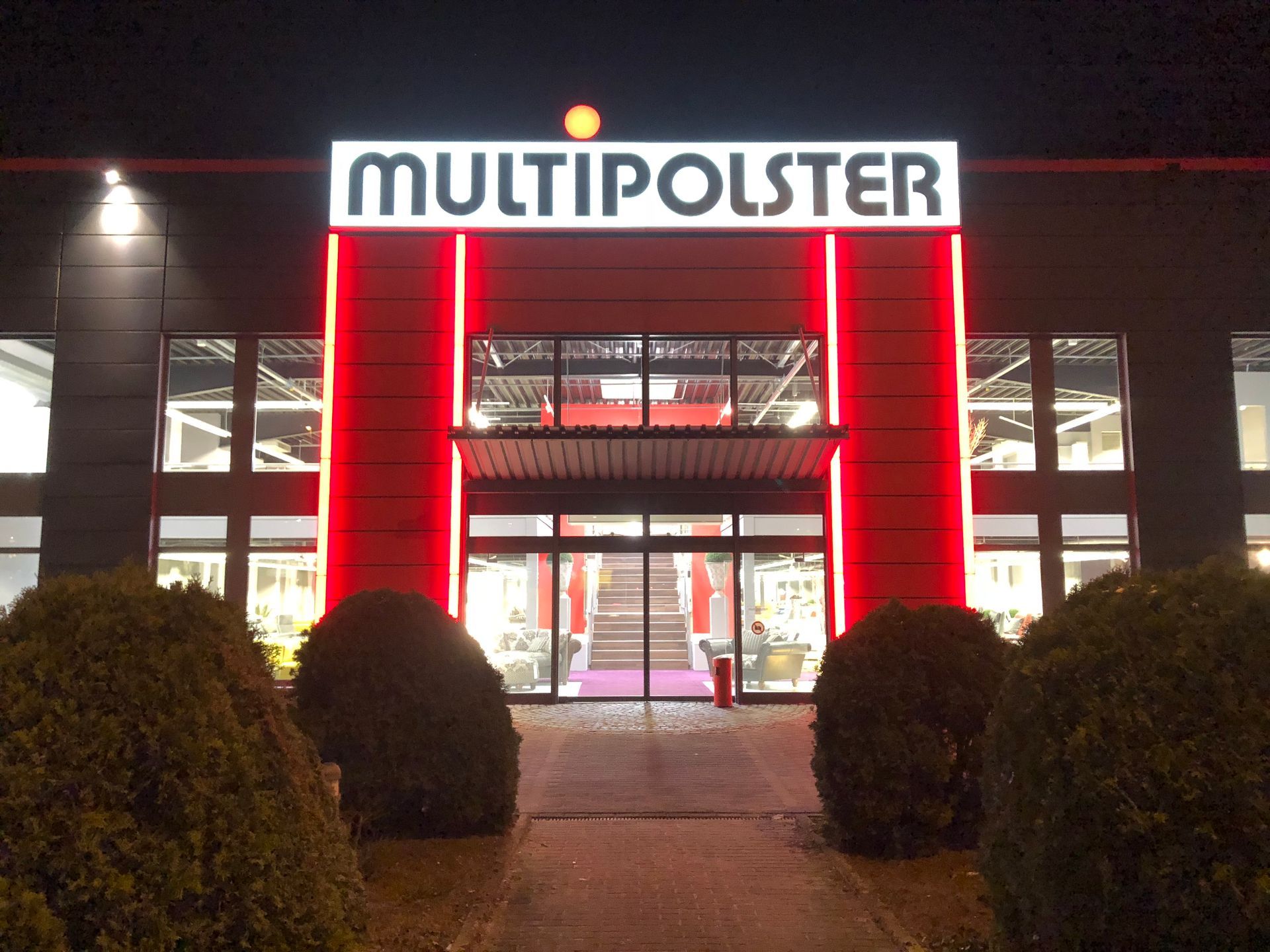 Werbeanlage Eingangsportal beleuchtet mit roten LED Konturen