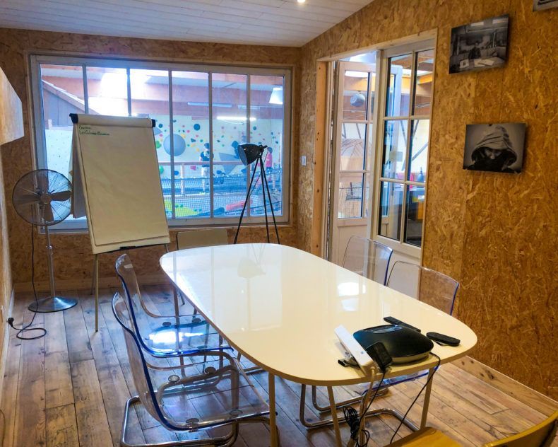Le bureau de Carole. Un espace vitré qui donne sur la salle d'escalade. Les murs sont en OSB et donne un style industriel à ce lieu atypique et très accueillant.