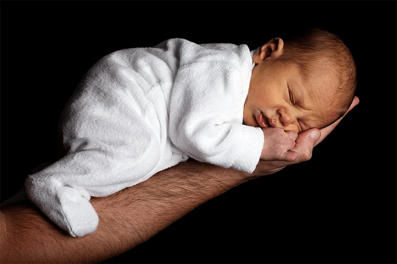 Baby schlaeft auf arm