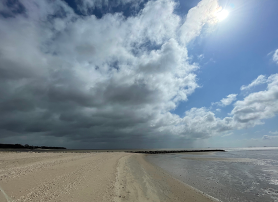 Föhrs Strände laden zu langen Strandspaziergängen ein - zu jeder Jahreszeit. Direkt erreichbar von unseren Ferienwohnungen. Leerer Strand mit dramatischer Wolkenformation über Föhr – perfekt für lange Spaziergänge.