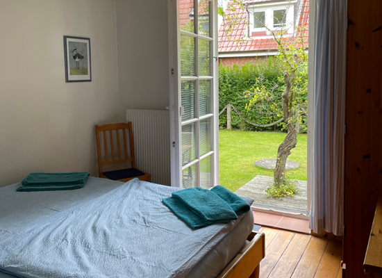 Haus Matthäus Ferienwohnung 1 (EG). Blick aus Schlafzimmer direkt in Garten, offene Terrasse mit urigem Baum. Sichtschutz.