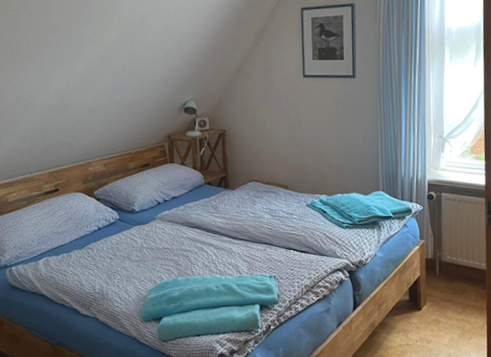 Haus Matthäus Ferienwohnung 2 (OG). Schlafzimmer mit Doppelbett. Dachschräge. Fenster zum Vorgarten. Ruhige Straße.