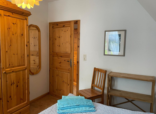 Haus Matthäus Ferienwohnung 2 (OG). Schlafzimmer mit Doppelbett, Kleiderschrank, Spiegel.