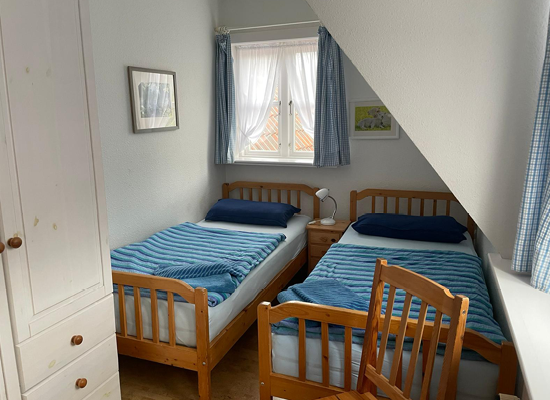 Haus Matthäus Ferienwohnung 2 (OG). Schlafzimmer mit 2 Einzelbetten. Dachschräge. Fenster Blick in Garten und zur Mühle.