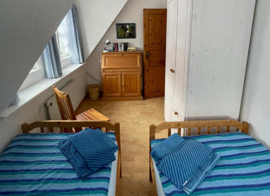 Haus Matthäus Ferienwohnung 2 (OG). Schlafzimmer mit 2 Einzelbetten. Sekretär (ausklappbar). Kleiderschrank. Blick in Garten.