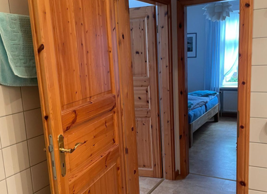 Blick aus Bad in den kleinen Flur. Verbindungstüren zu beiden Schlafzimmern und rechts zu Wohnküche und Wohnzimmer.