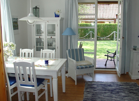 Haus Matthäus Ferienwohnung 3 Anbau. Wohnzimmer mit Esstisch, gemütlicher Sitzecke. Tür zur überdachten Terrasse.