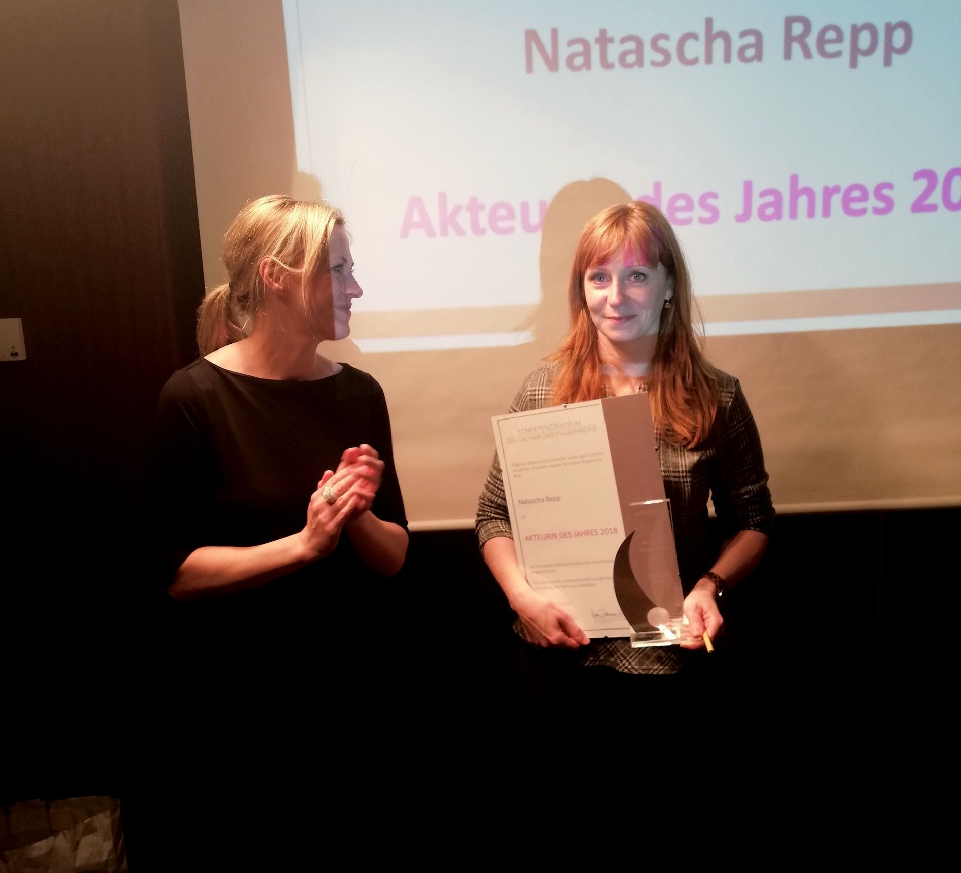 links: Nadine Dammann-Esch (Geschäftsführerin Kompetenzzentrum Deutscher Zweithaarprofis) zeichnet Natascha Repp (rechts) zur Akteurin des Jahres 2018 aus