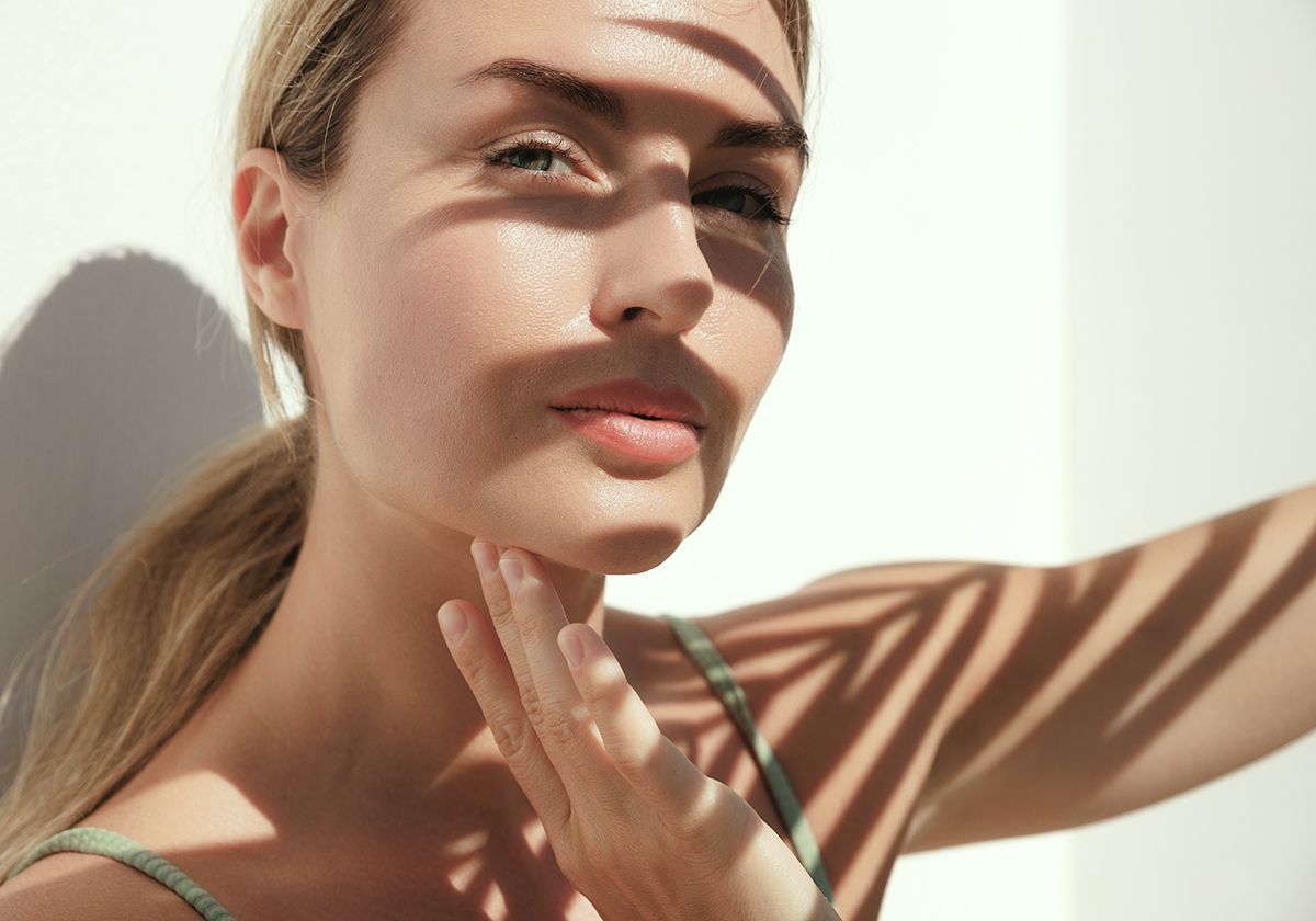 Zwischen 11 und 16 Uhr: Direkte Sonne vermeiden – besonders bei Problemhaut Frau meidet direkte Mittagssonne – UV-Schutz-Empfehlung für empfindliche Haut im Hochsommer