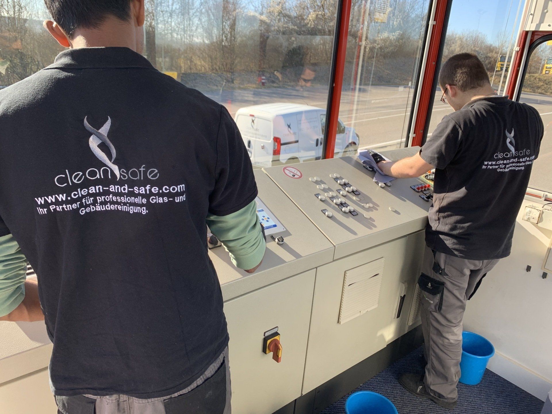 Clean & Safe Mitarbeiter reinigen die Steuerkabine einer Industrieanlage