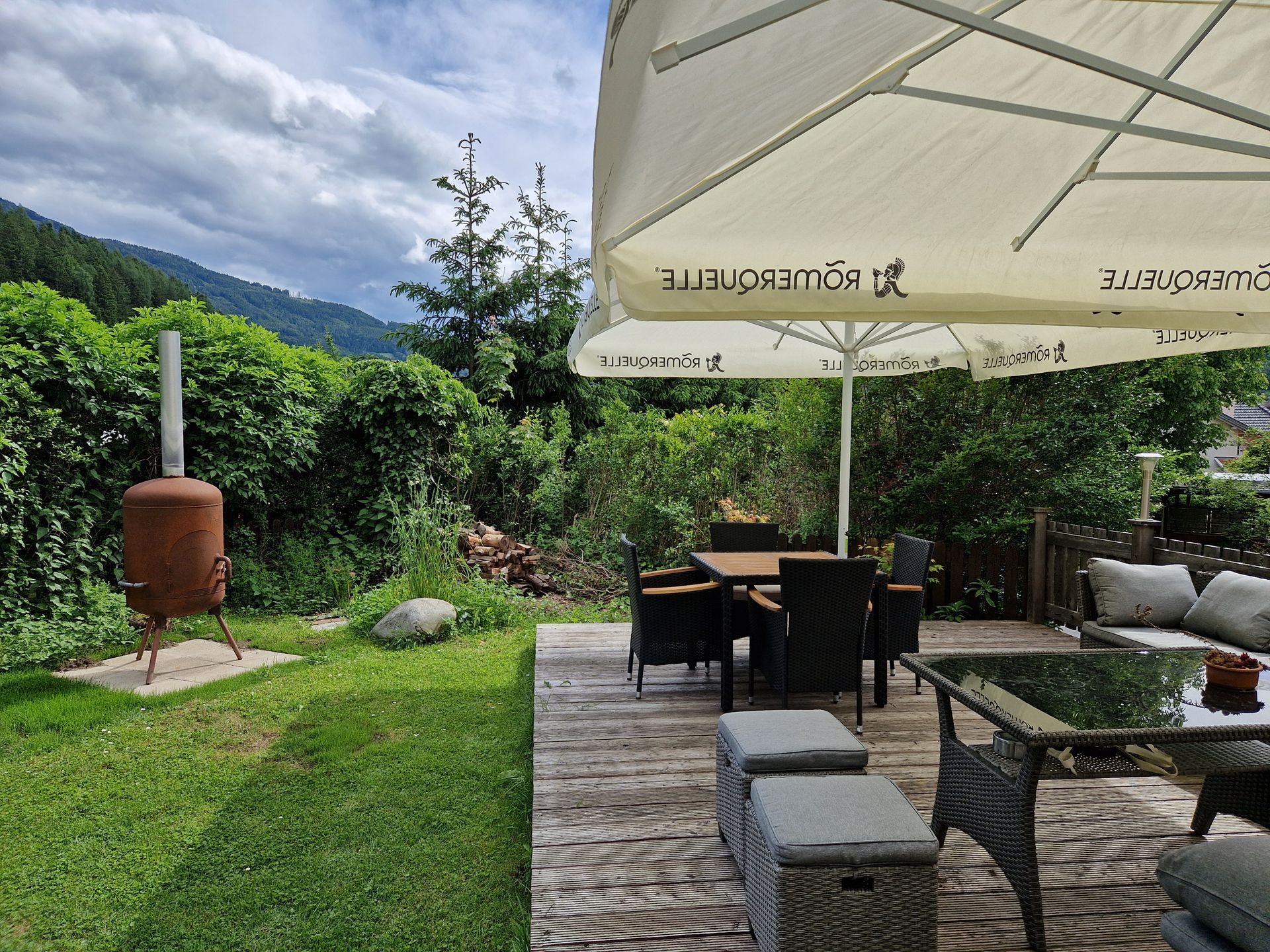 Pension Sonnenheim Gmünd in Kärnten, Österreich, Blick auf Gartenlounge mit Sonnenschirm und Sitzmöglichkeiten