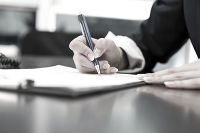 Cliente firmando la presentación de una denuncia delante de los abogados de Mondragón Abogados.