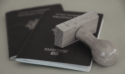 Pasaportes recién estampados y clientes firmando trámites necesarios para la obtención de un visado en España.