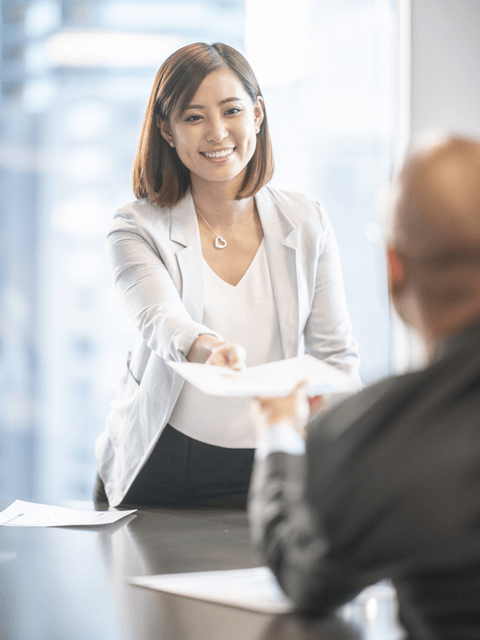 A smiling woman hands in her CV
