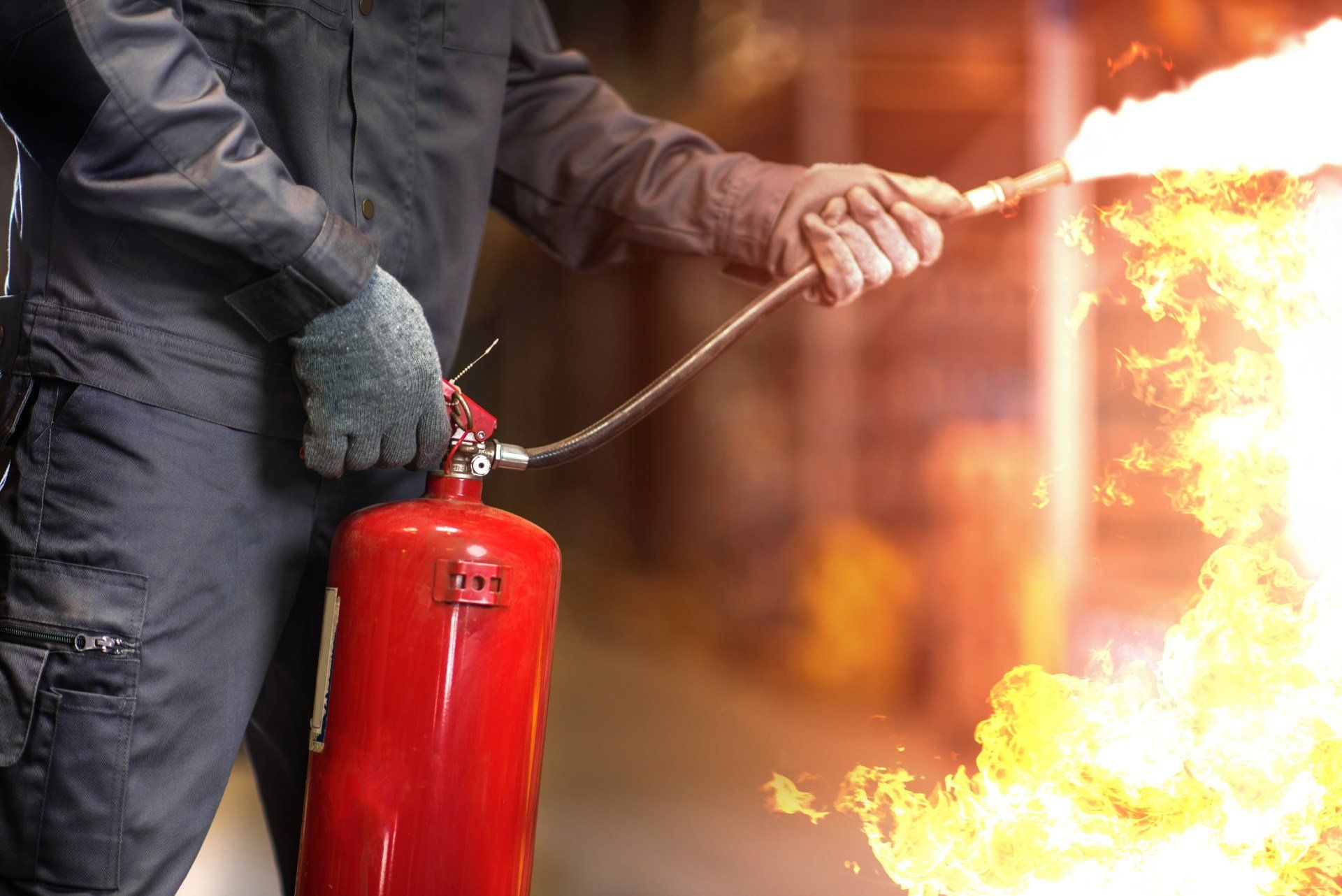 homme eteignant un feu avec un extincteur