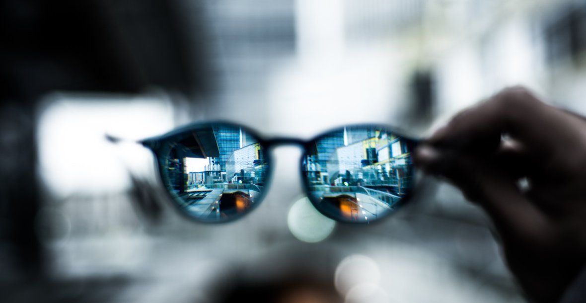 Reading glasses held out  reflecting  focus on need for psychology and Mental Health