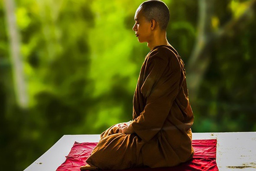Moine bouddhiste en zazen sur un coussin de méditation