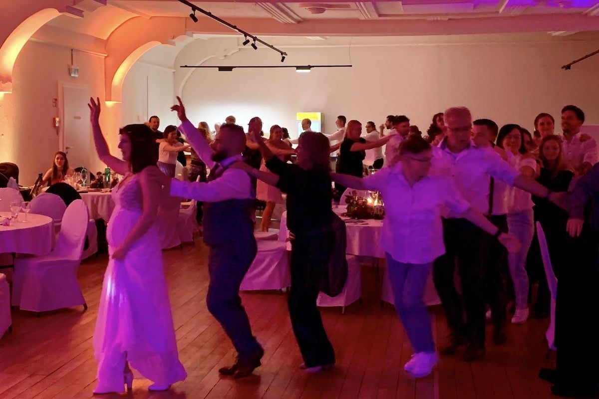 Das Bild zeigt eine ausgelassene Feier mit Tanz und Musik