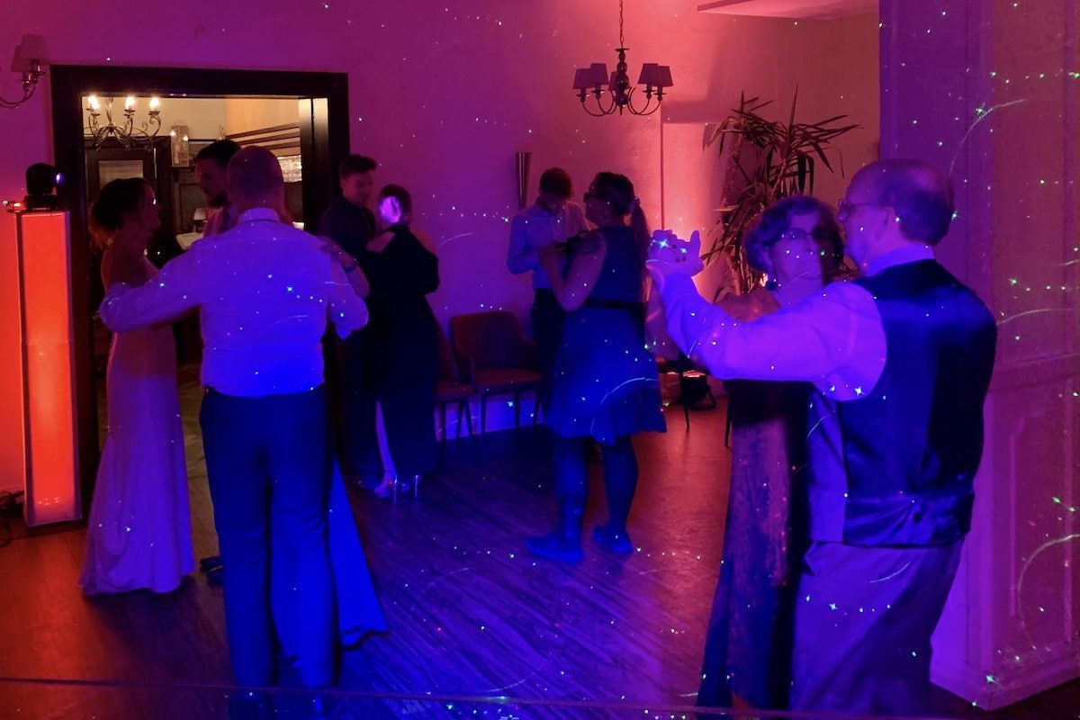 Das Bild zeigt eine dynamische Party mit Tanz und Musik