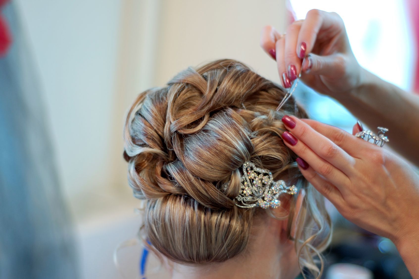 Bride having hair styled for her wedding.