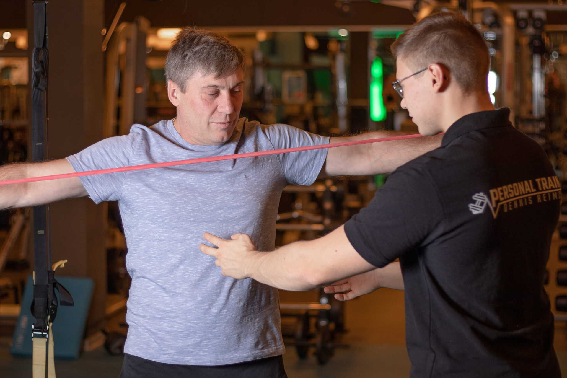 Personal Trainer mit seinem Klienten in einem Fitnessstudio