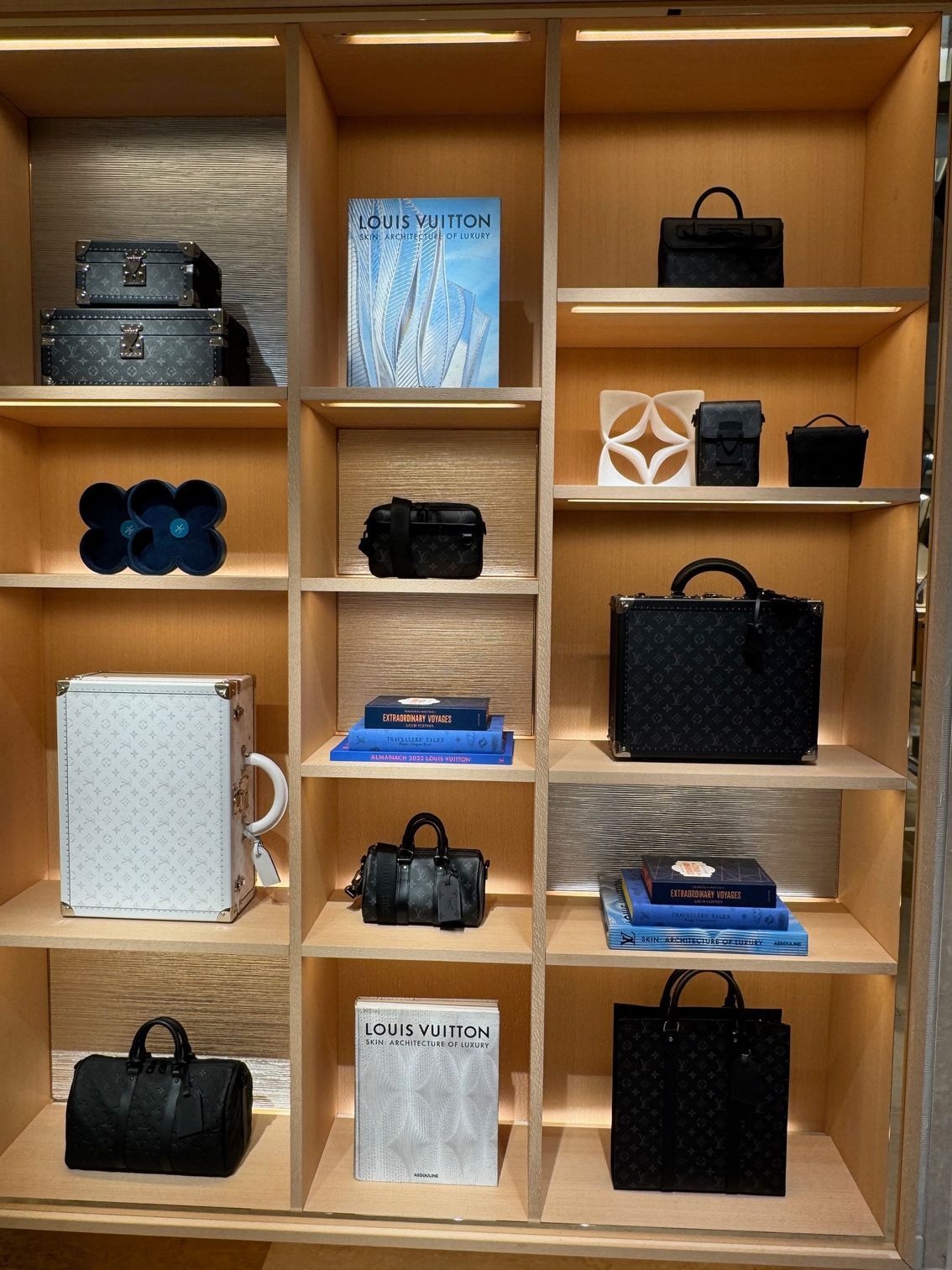 Scaffali di una boutique di Milano con esposte valigie, borse, libri e altri accessori.
