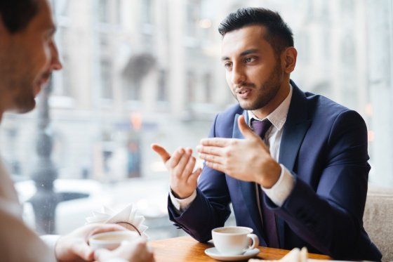 two people having a conversation over coffee