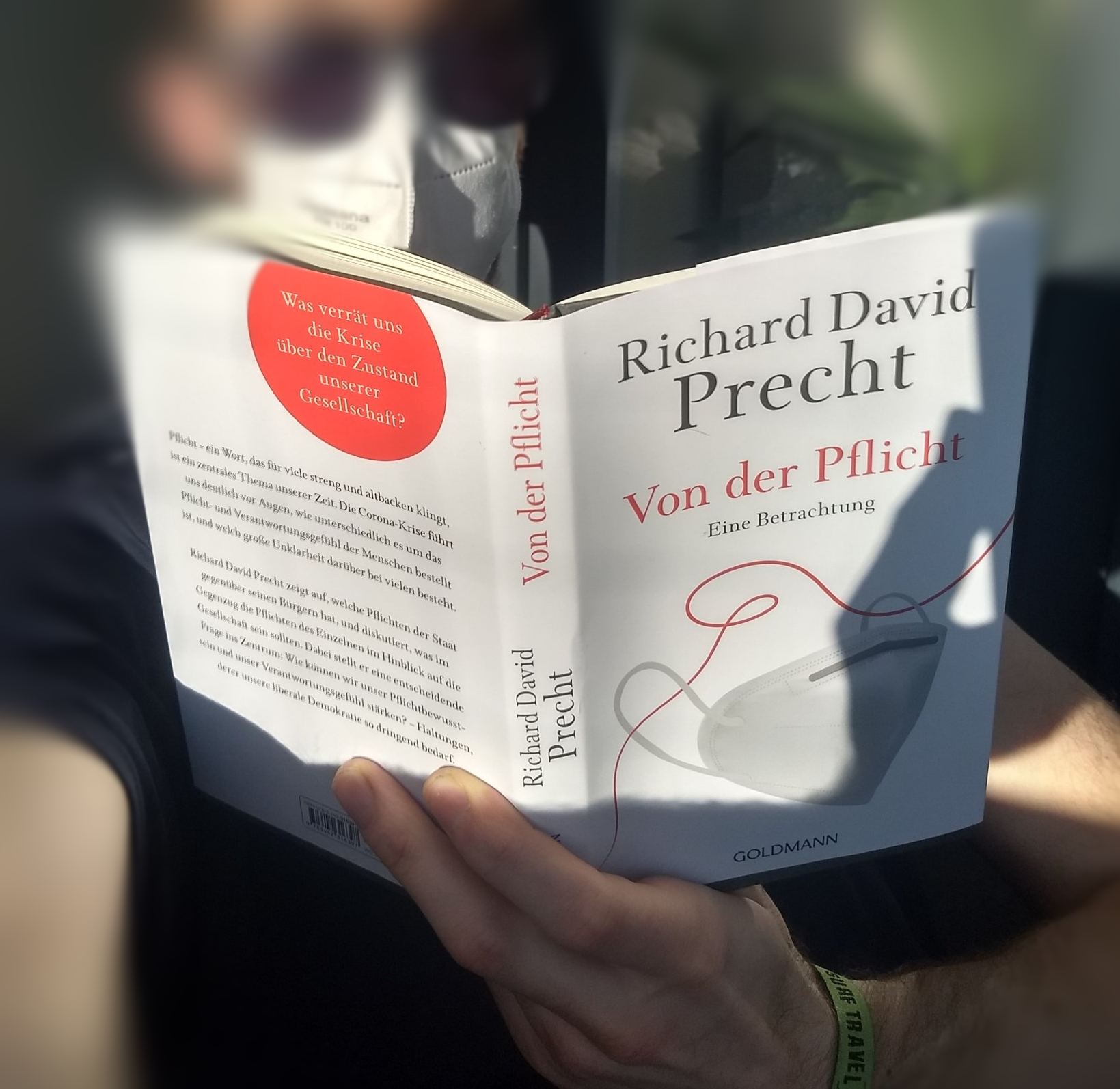 Mann liest mit Maske das Buch