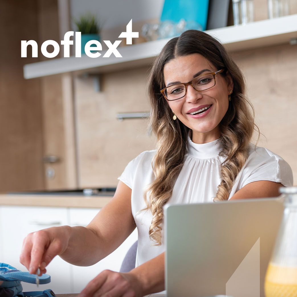 Eine Frau mit Brille schau entspannt durch eine entspiegelte Brille auf ihren Laptop.