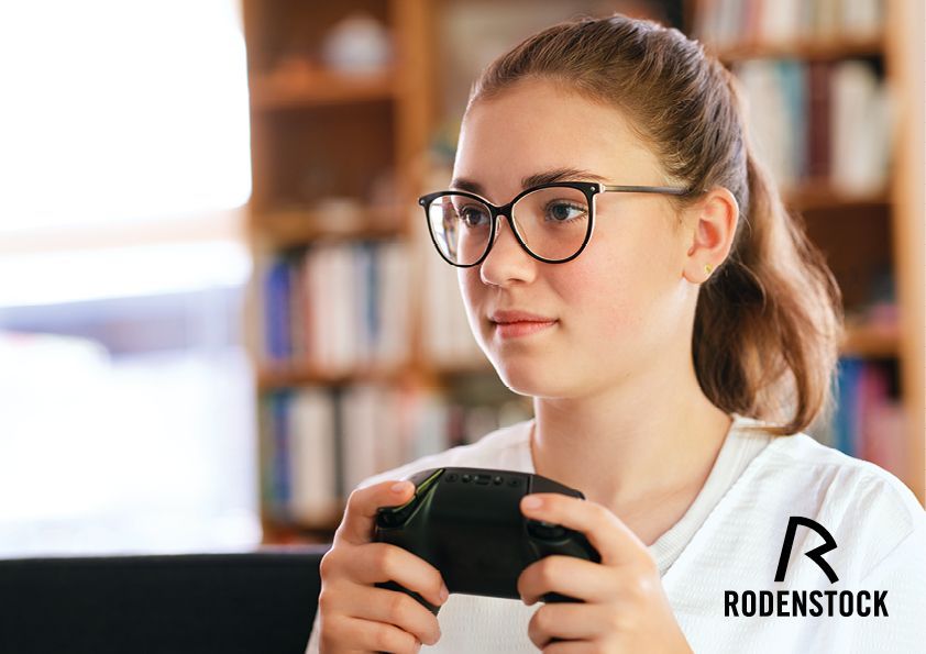 Mädchen mit Brille und GameController in der Hand