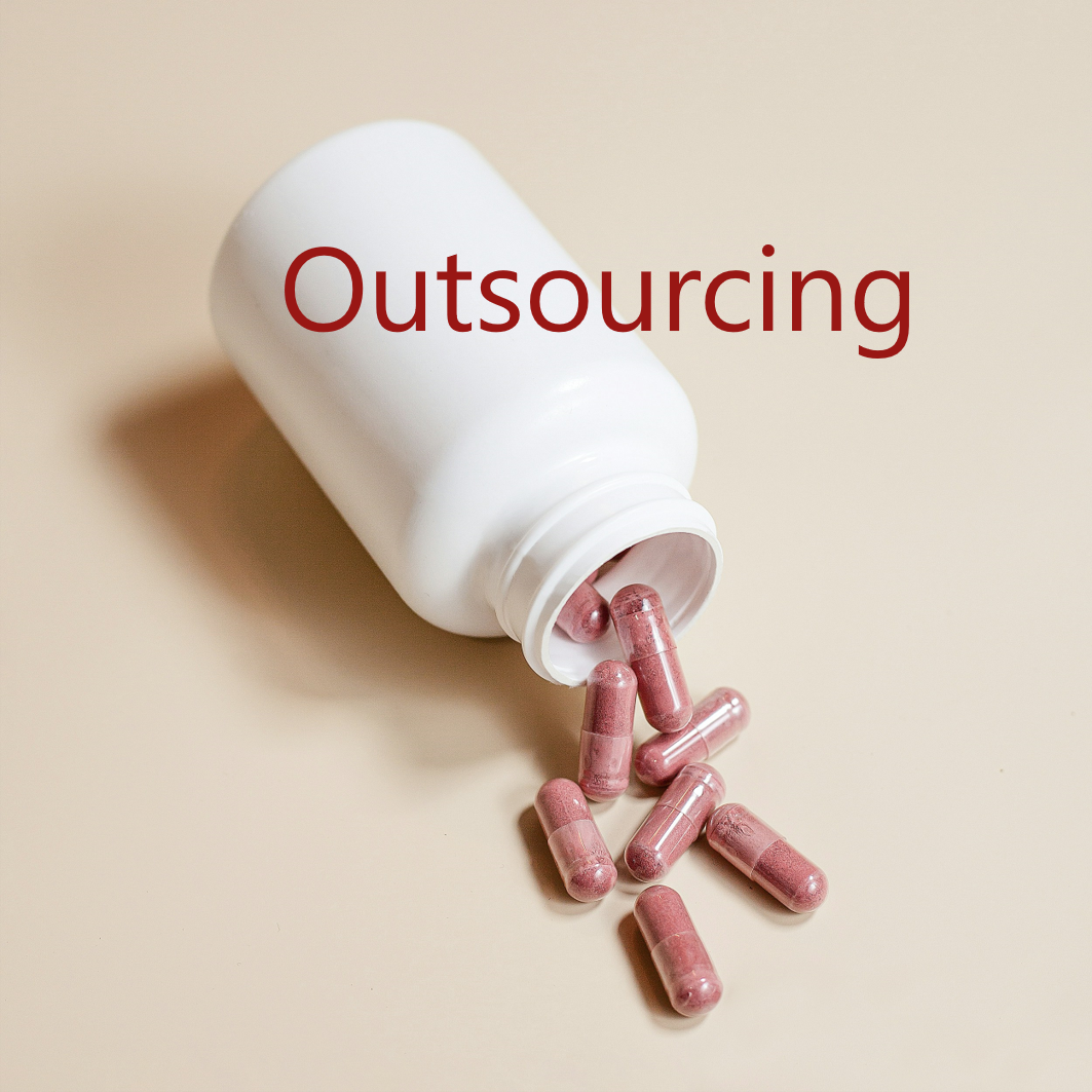 Geöffnete Medikamentendose aus der Kapseln herausfallen und dem Schriftzug Outsourcing