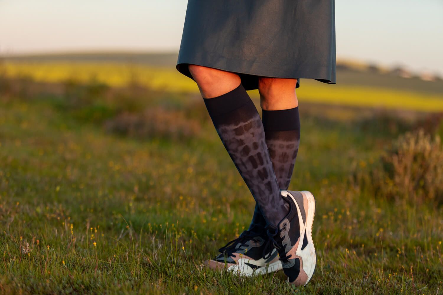 Foto von den Beinen eines Mannes und einer Frau, die mit Kompressionsstrümpfen einen Spaziergang machen